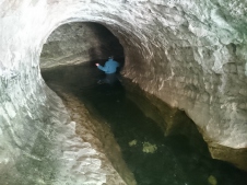 Cave Stream ieeja. Ar džemperi mugurā un cepuri galvā peldam iekšā nezināmajā.